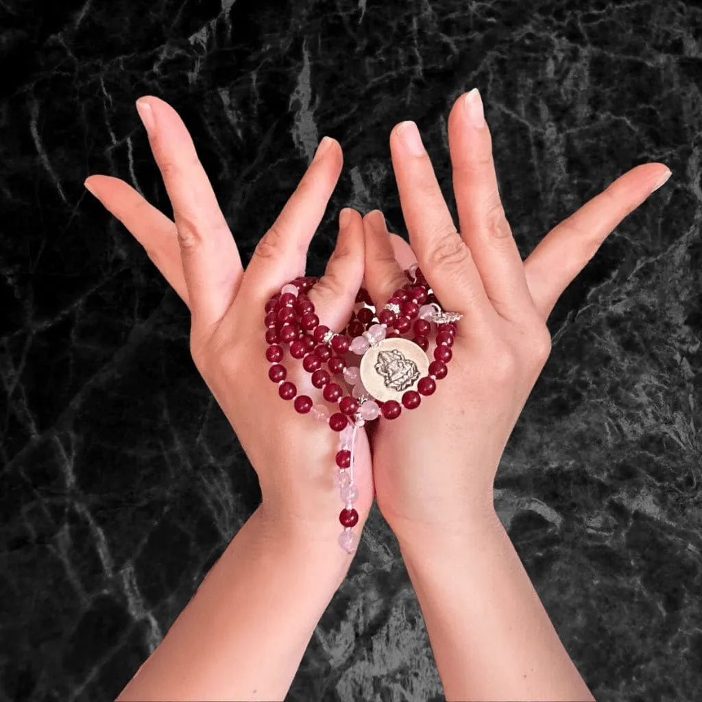 Mani in mudra con japamala, simbolo dei materiali e dei componenti sacri che la compongono. Hero mobile  della pagina Umadevi dedicata alla struttura e agli elementi di una japamala.