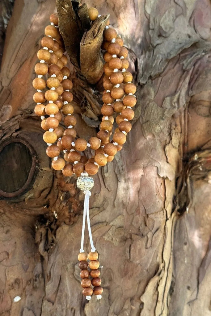 Japamālā realizzata con grani di legno di sandalo naturale, strumento di preghiera e meditazione che favorisce calma e raccoglimento interiore.