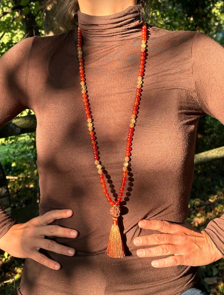 Japamālā Diwali indossata lunga, con la nappina sul davanti e il pendente Oṃ che cade dolcemente dietro al collo.