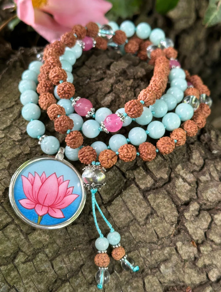Japamālā con grani di Giada rosa, Amazzonite, Quarzo Ialino e Rudrakṣa avvolta a spirale su un tronco