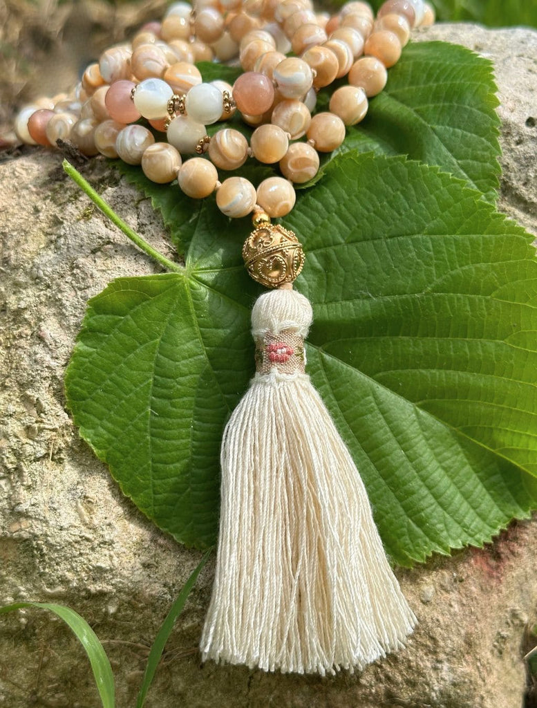 Mala con nappina floreale, il simbolo dei mille petali del chakra corona.