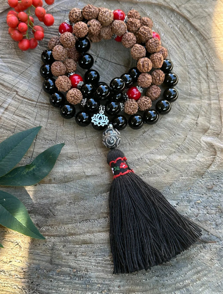 Japamala da 72 con Onice nero, Corallo Bambù e semi di Rudrākṣa, guru beads in argento, nappina decorata, piccolo pendente loto.