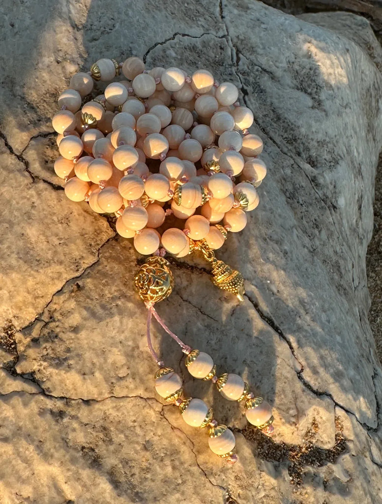 Mala Shanka (la conchiglia di Vishnu) realizzata con grani in conchiglia rosa naturale e pendente a conchiglia argento dorato