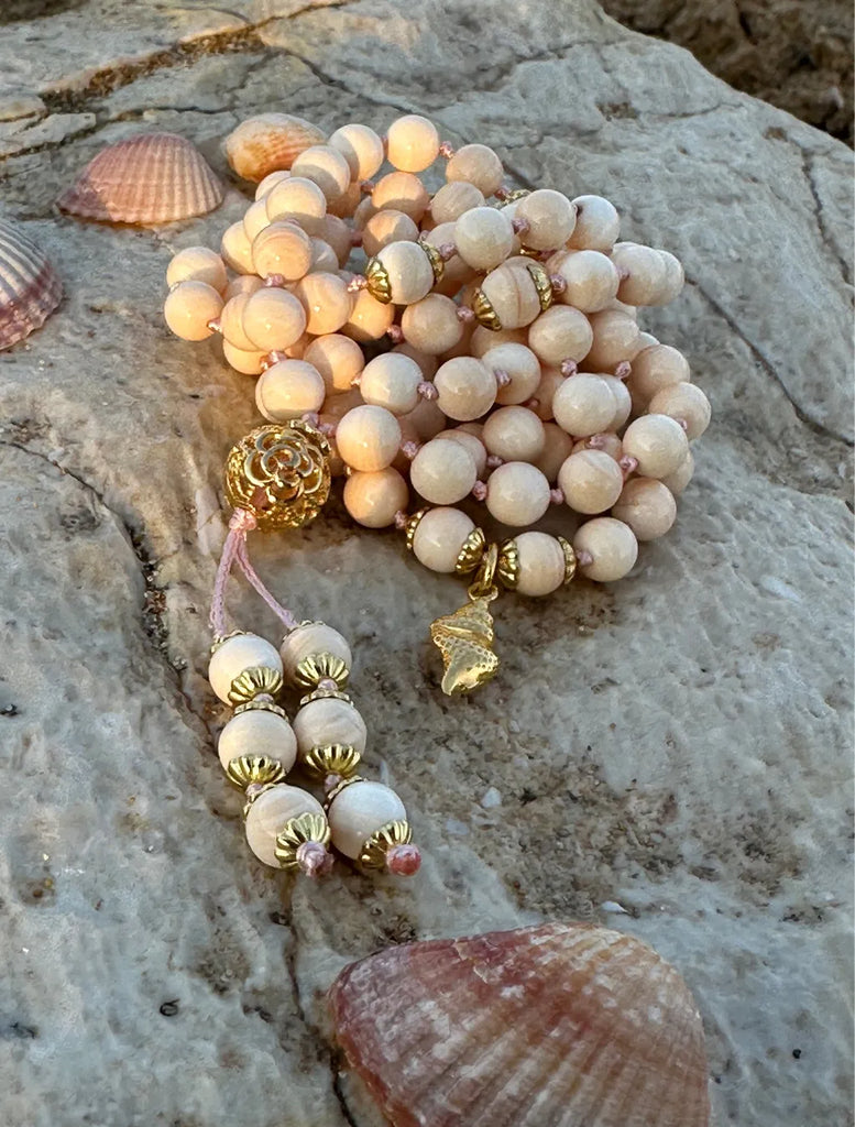 Japamala artigianale con grani di conchiglia rosa naturale e pendente sacro shankha, la conchiglia di Vishnu, in argento dorato. Minuteria in argento dorato