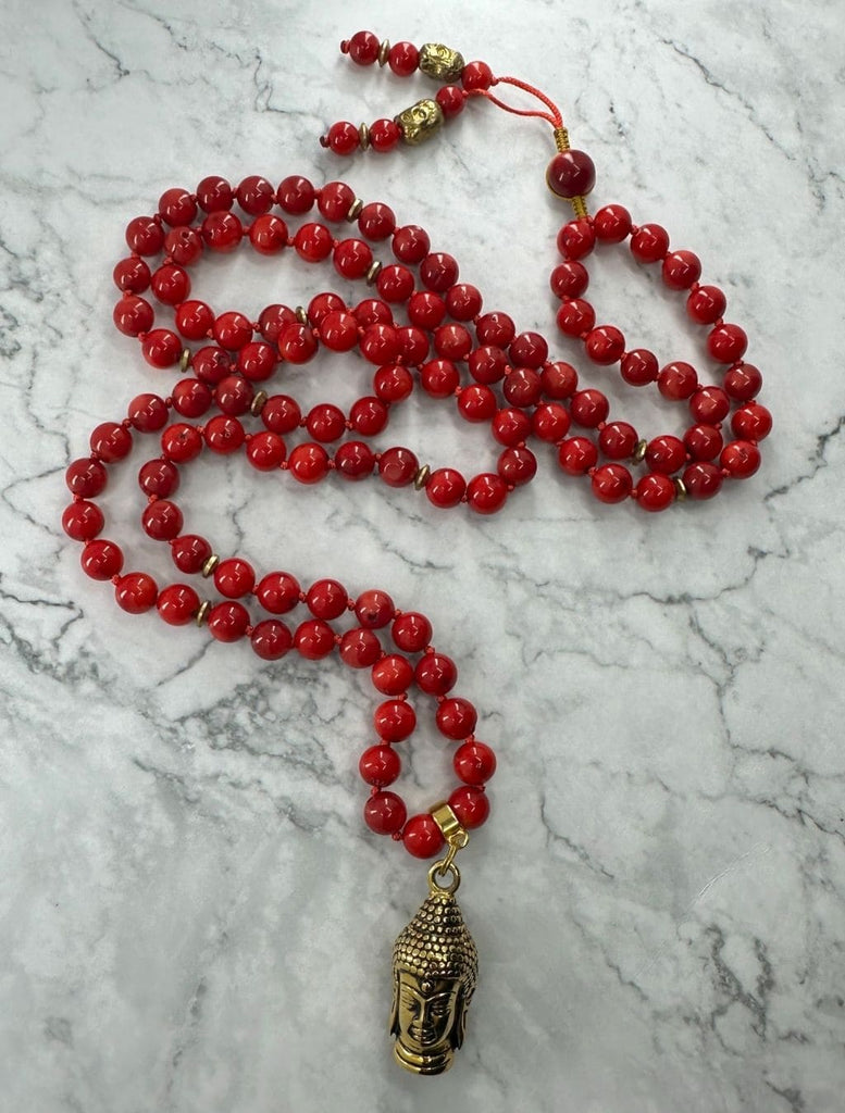 Mala 108 grani di corallo bambù con pendente testa del Buddha: vista dall’alto e distesa nella sua lunghezza per una visione d’insieme.