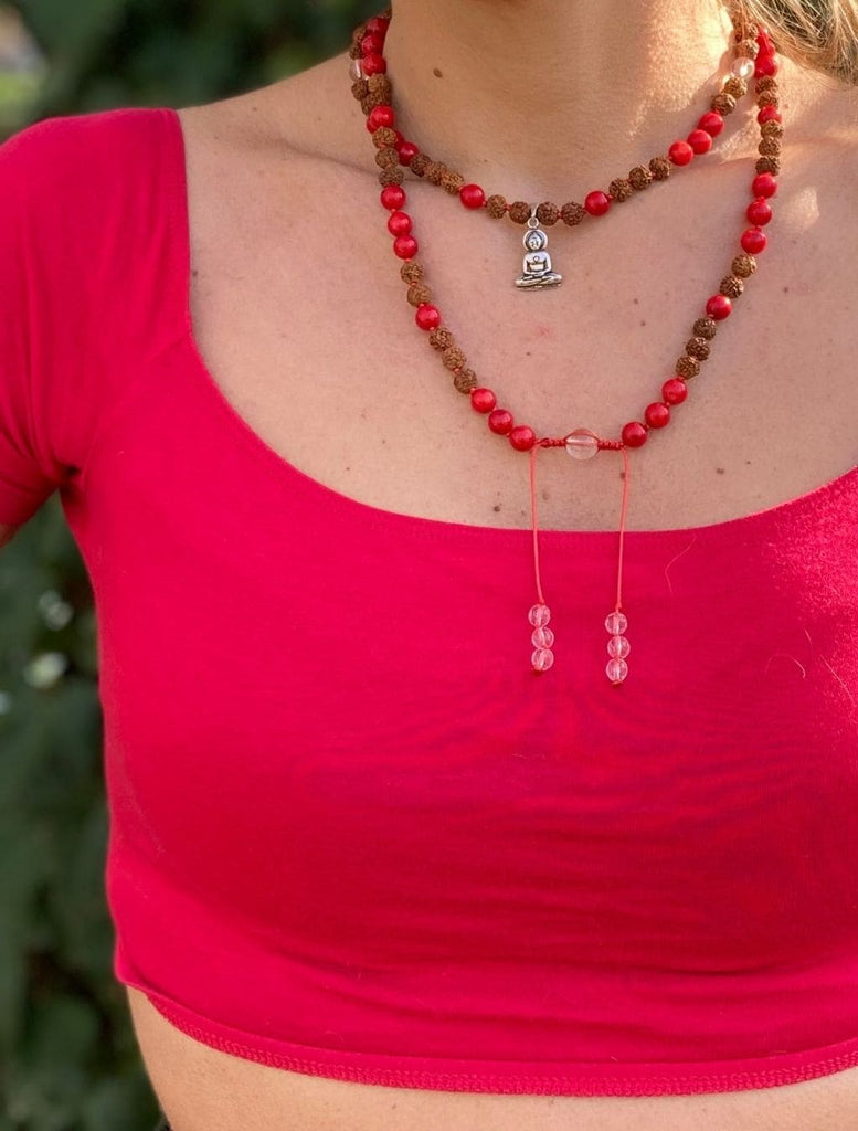 Japamala con 108 grani di Rudraksha, Quarzo Ialino e Corallo di Bambu, pendente Buddha in argento, indossata a doppio giro per una visione completa.