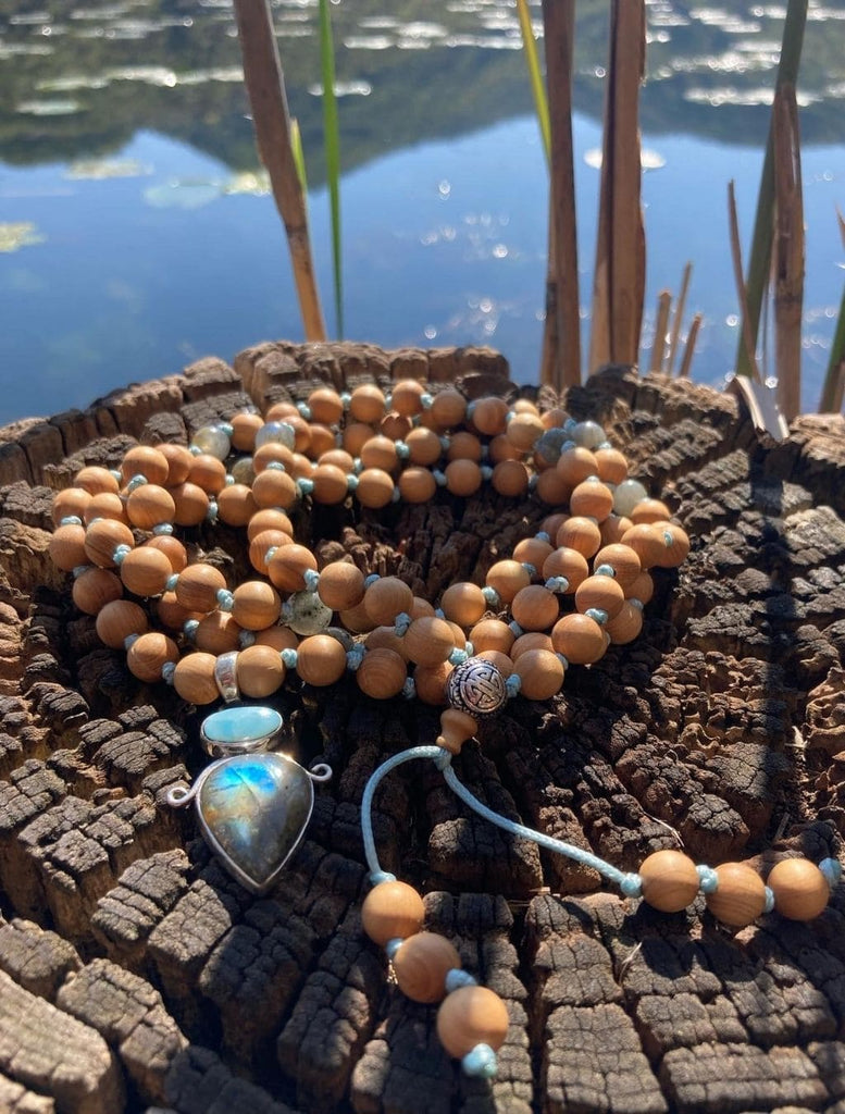 Japamala in legno di sandalo decorato con pendente argento in Angelite e Labradorite. In evidenza i riflessi magici della Labradorite.
