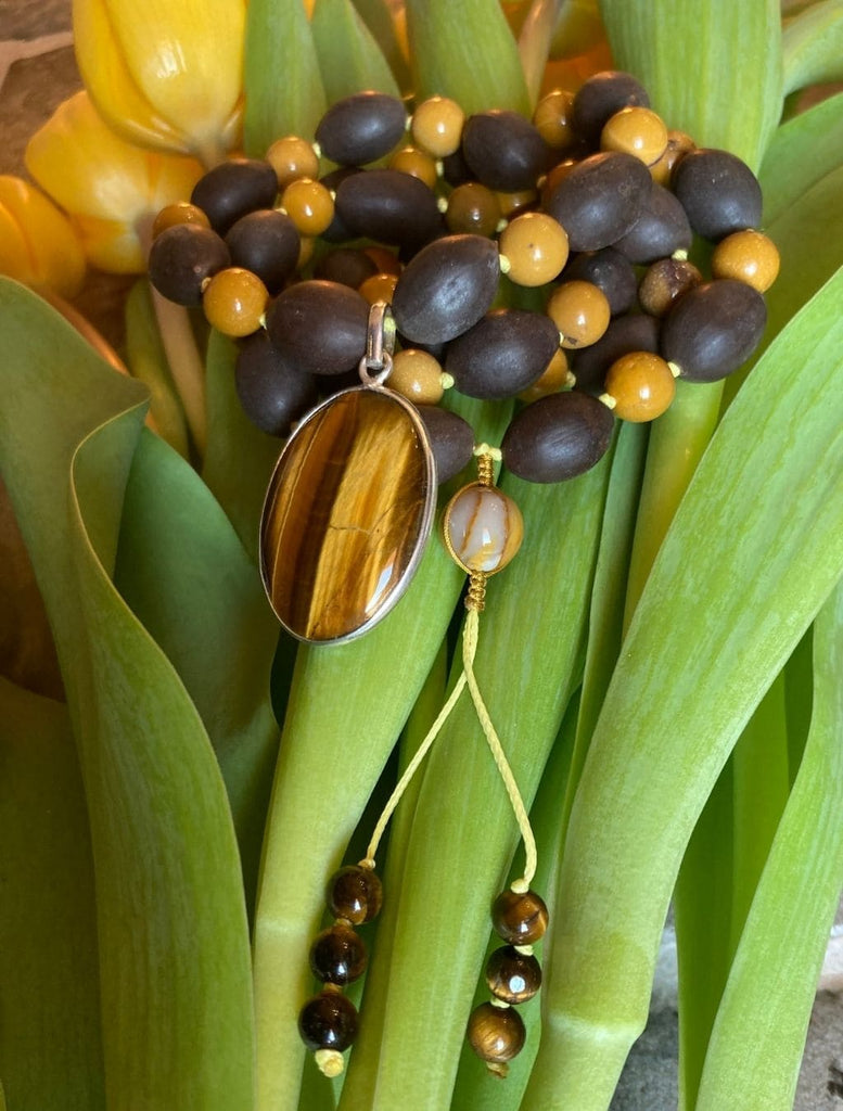 Mala con Semi di Loto, Mokaite e pendente Occhio di Tigre in argento. Dettaglio dei grani, del guru e del pendente.
