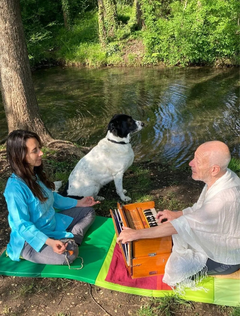Umadevi canta un mantra accompagnandosi dall’harmonium Immagine che celebra la devozione e la diffusione del potere del suono sacro.